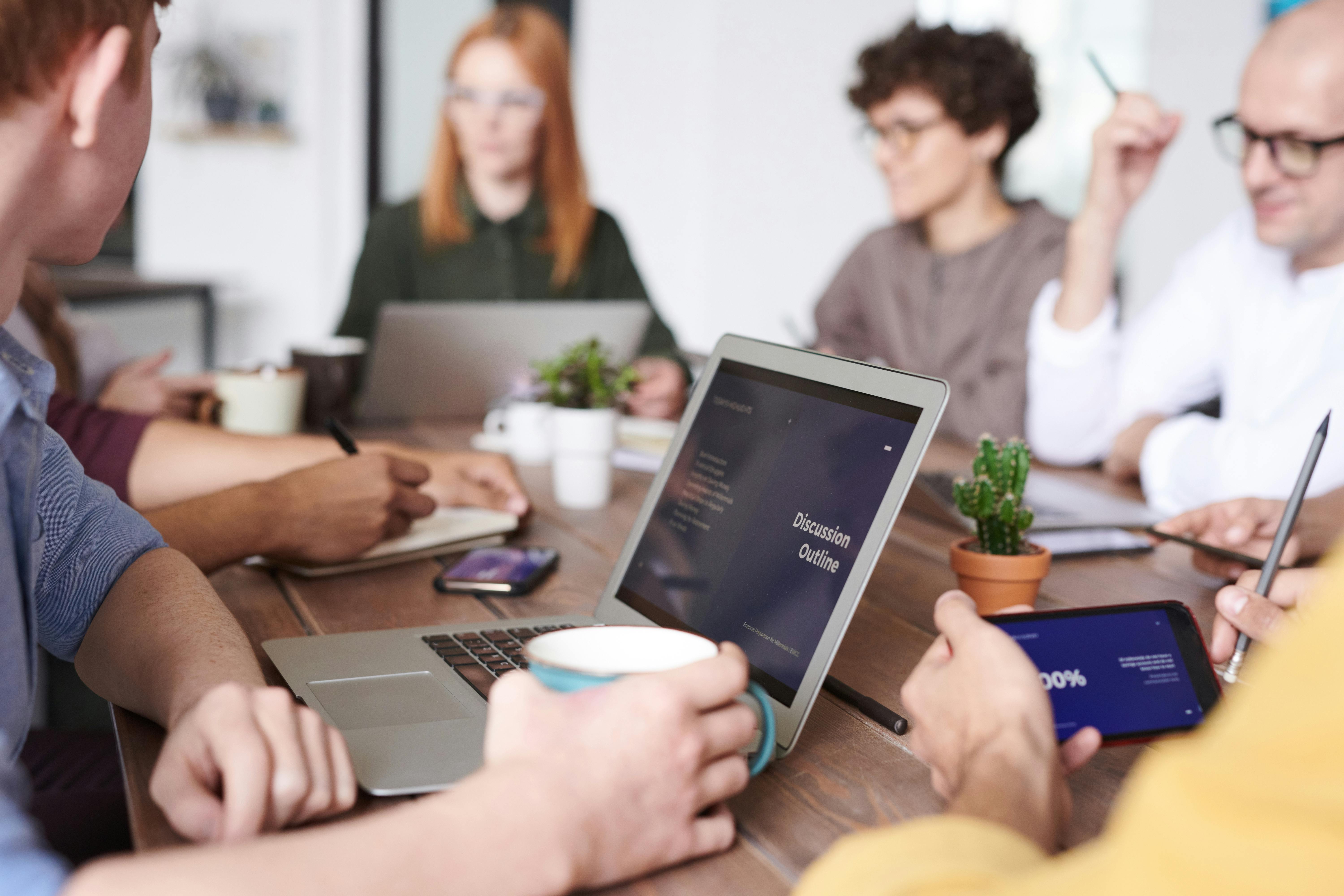 Group of people at a meeting with laptops