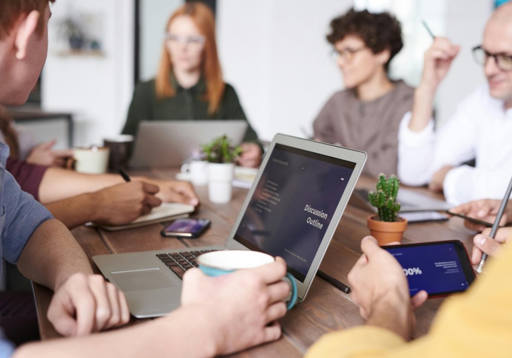 Group of people at a meeting with laptops