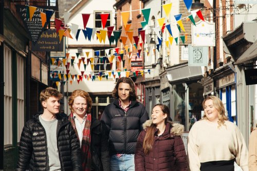 NMITE integrated engineering students walking along Hereford streets with bunting behind them