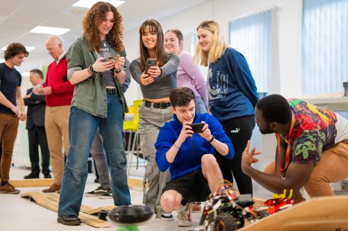 NMITE students grouped together taking a photo in the studio of their mechatronics module outcome