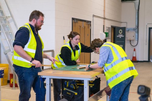 Three people in high vis doing a timber course
