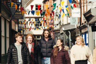 NMITE integrated engineering students walking along Hereford streets with bunting behind them