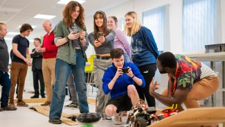 NMITE students grouped together taking a photo in the studio of their mechatronics module outcome