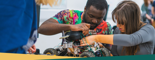 Two NMITE students, one male and one female working on a remote control car