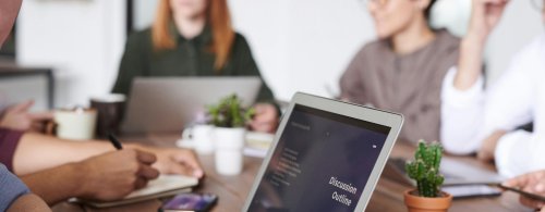 Group of people at a meeting with laptops